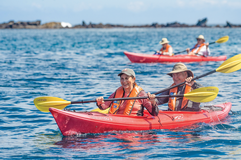 Guests explore the Buccaneer Cove by kayak at Santiago Island, Galapagos, Ecuador