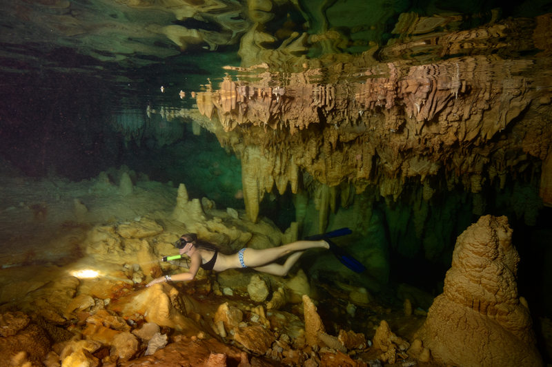 A guest explores underwater caves in Tuamotus Islands, Makatea, French Polynesia