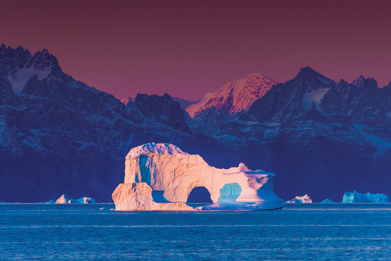 Pink sunlight on an Iceberg Arch near Greenland