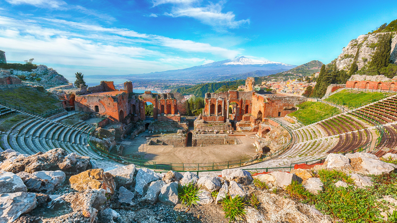 Ruins of ancient Greek theater in Taormina and Etna coast of Giardini-Naxos bay, Sicily, Italy, Europe