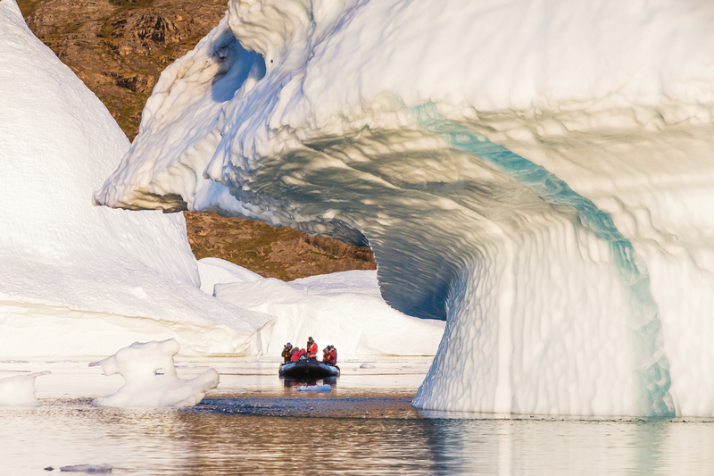 Guests explore icebergs by zodiac from the ship National Geographic Explorer near Rode O (Red Island), Scoresbysund, Northeast Greenland.