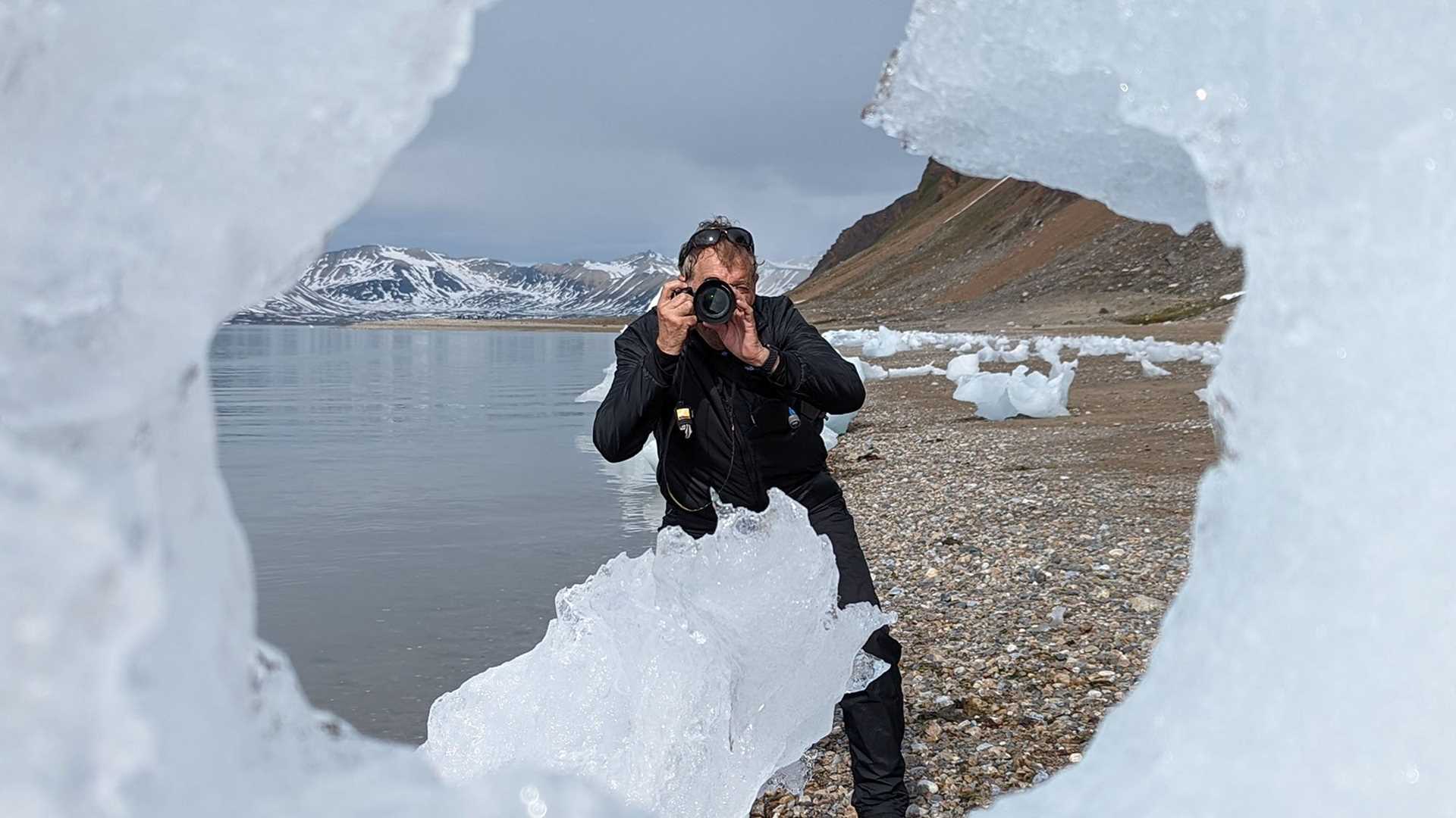 photographer standing in the middle of an iceberg