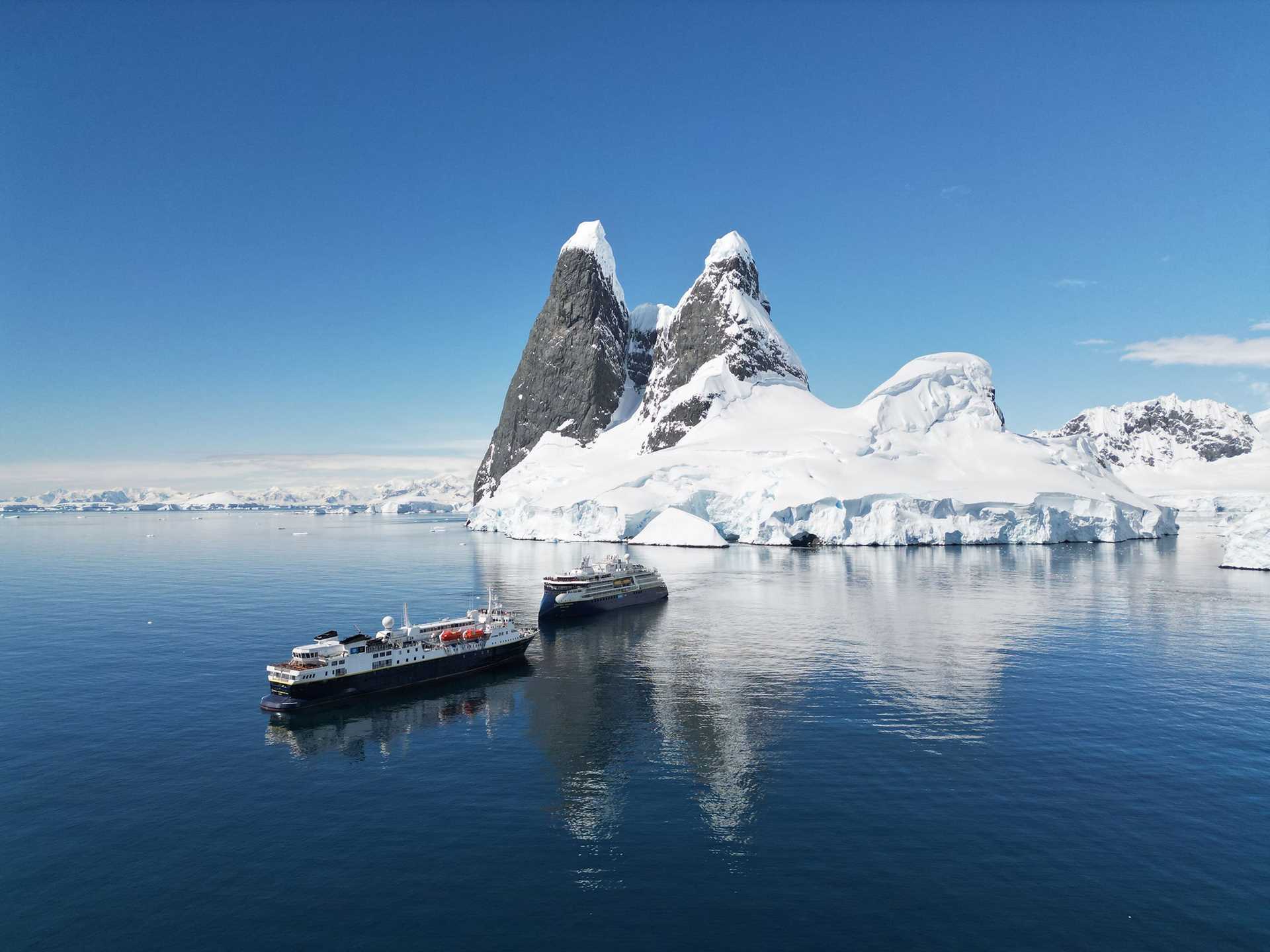 two ships in front of an iceberg