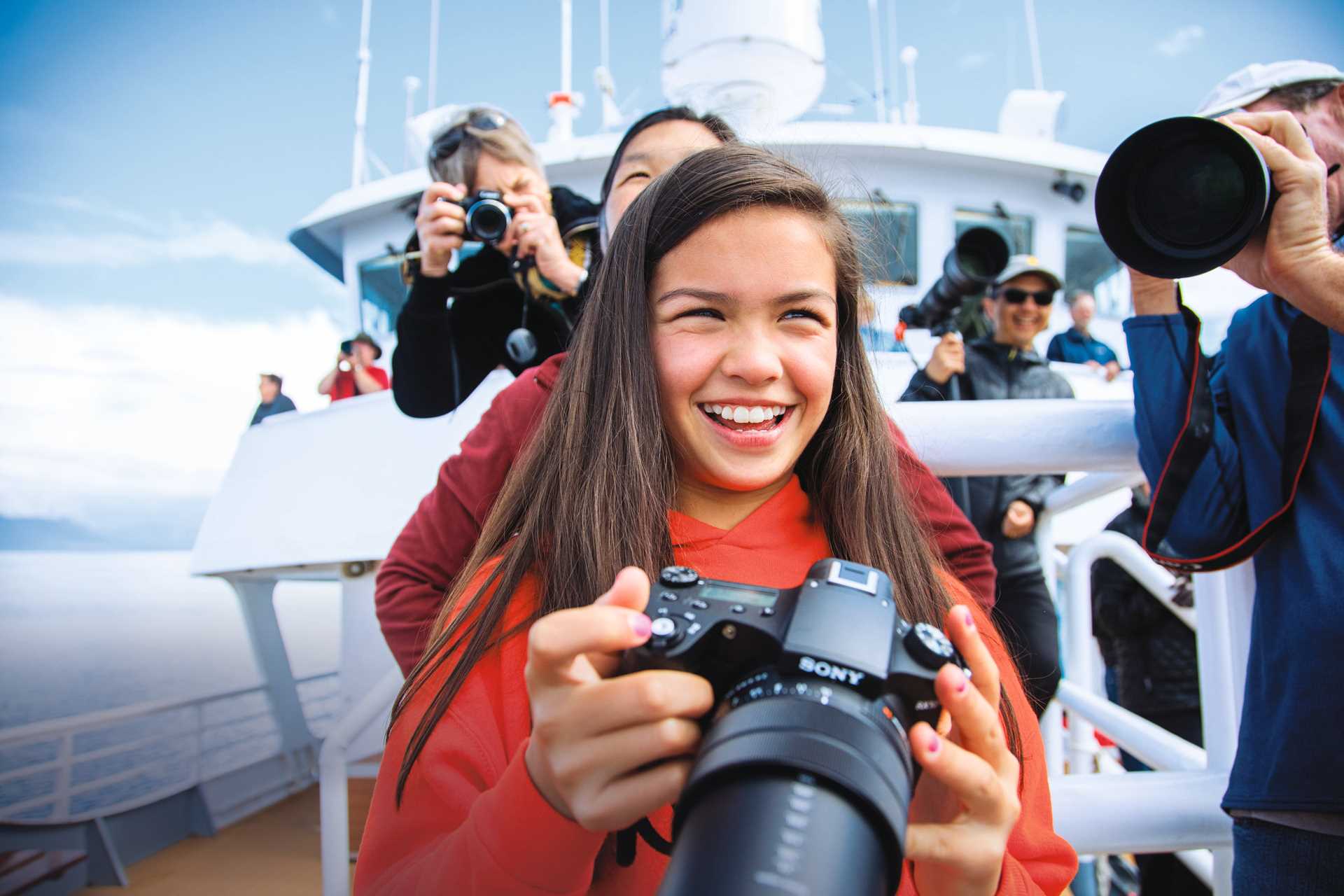 A young guest takes a photo from the bow of the National Geographic Sea Bird