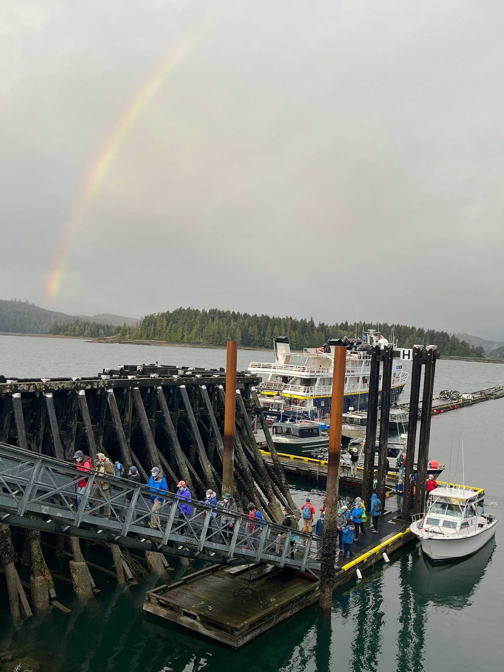 guests board a ship with a rainbow in the background