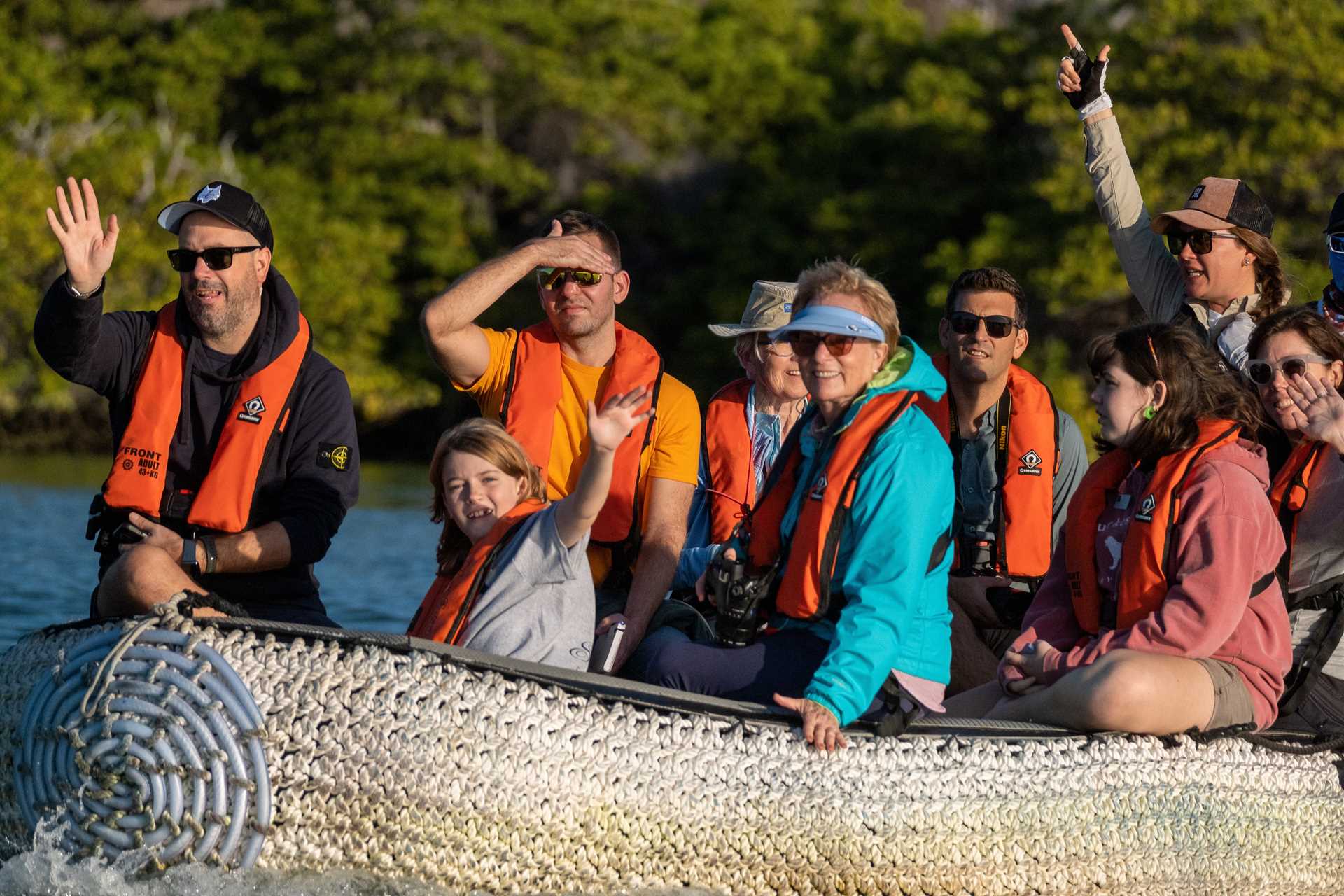 A family travels on a Zodiac boat in Galápagos.