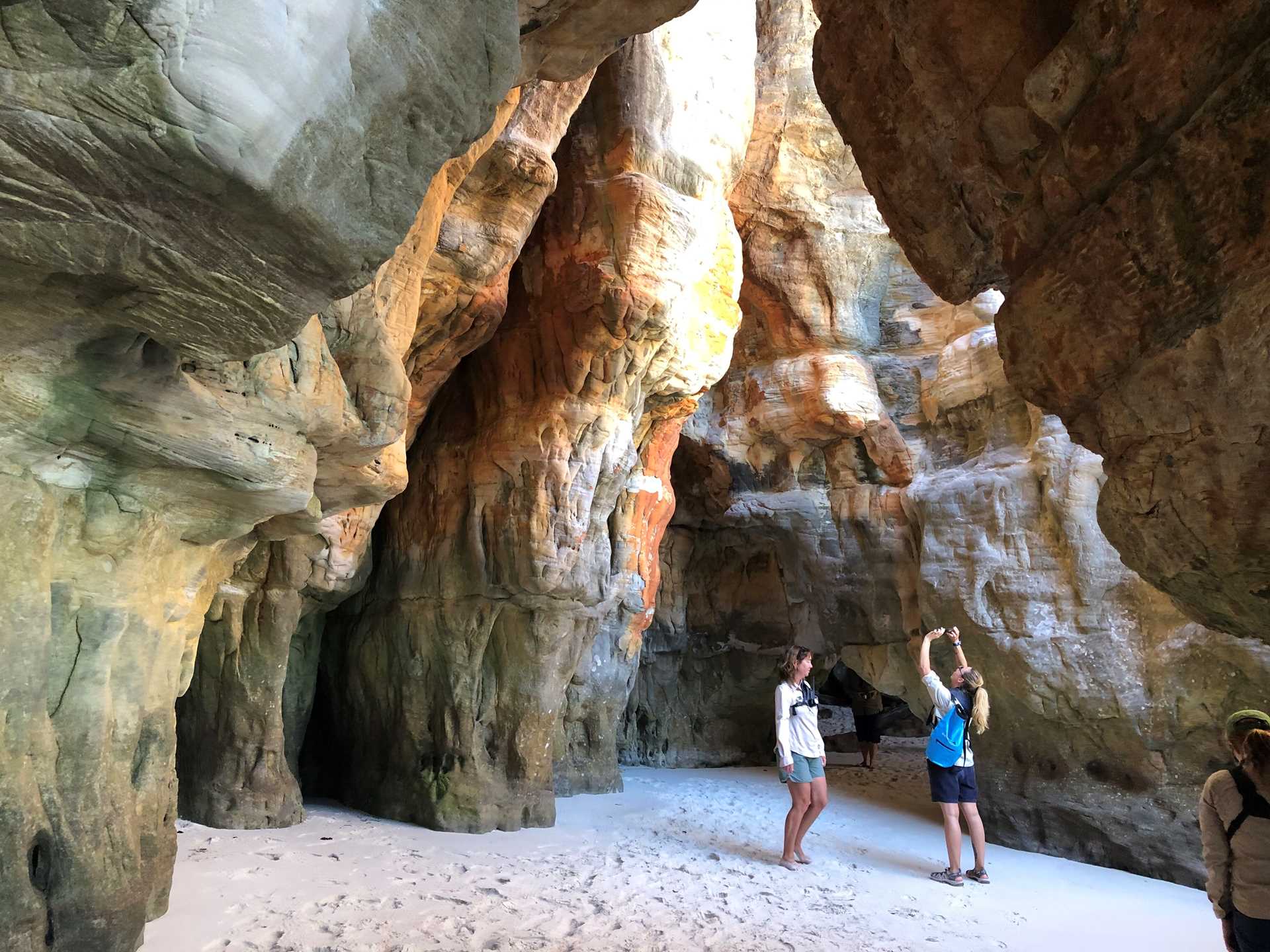 two women photographing a cave