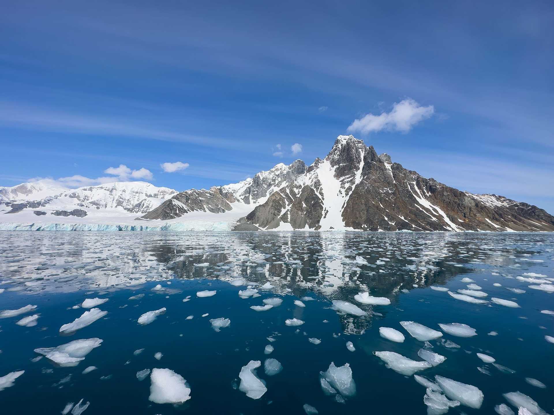 a mountain reflected in icy water