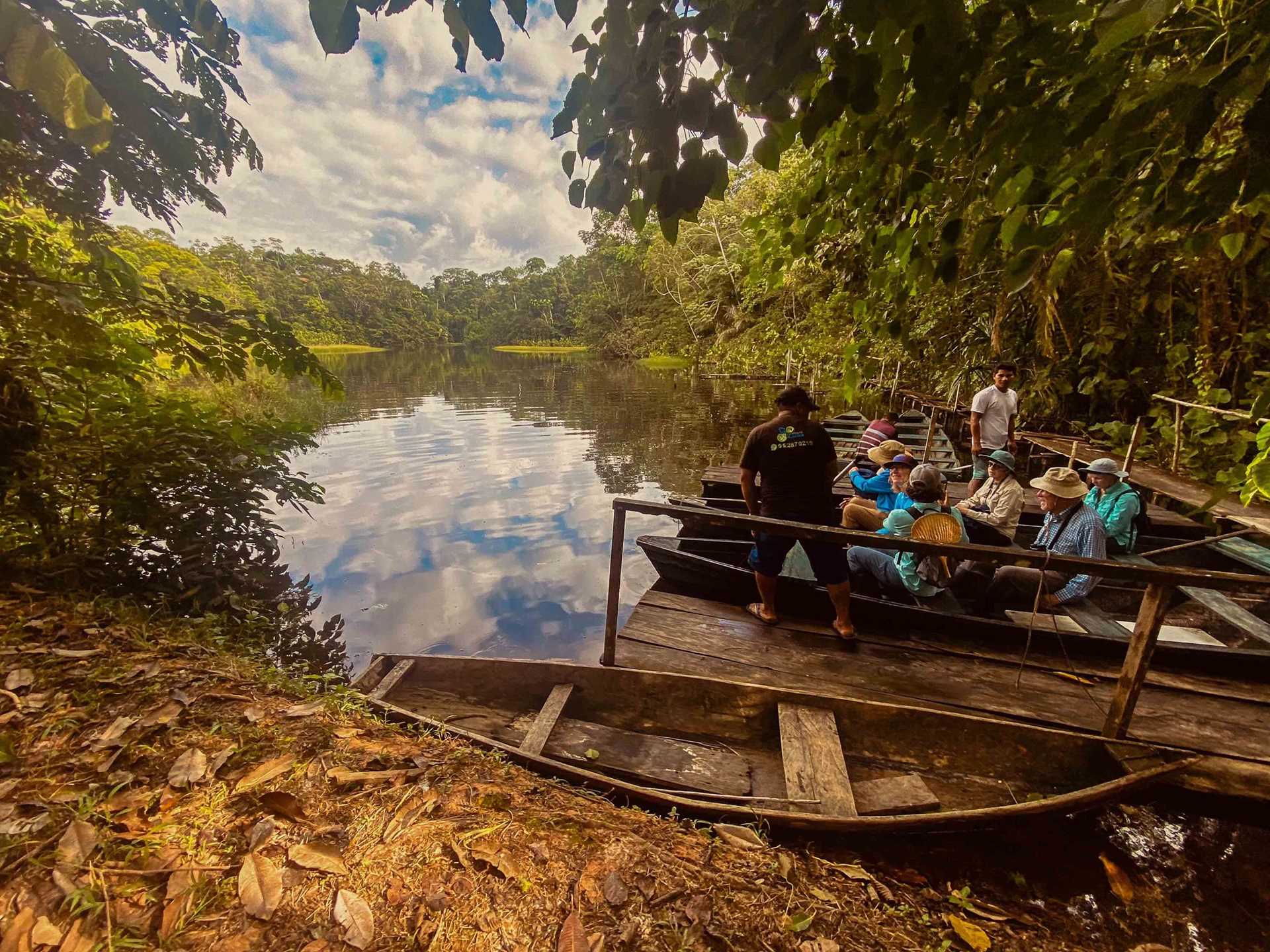 people in a small boat in a lagoon in the amazon