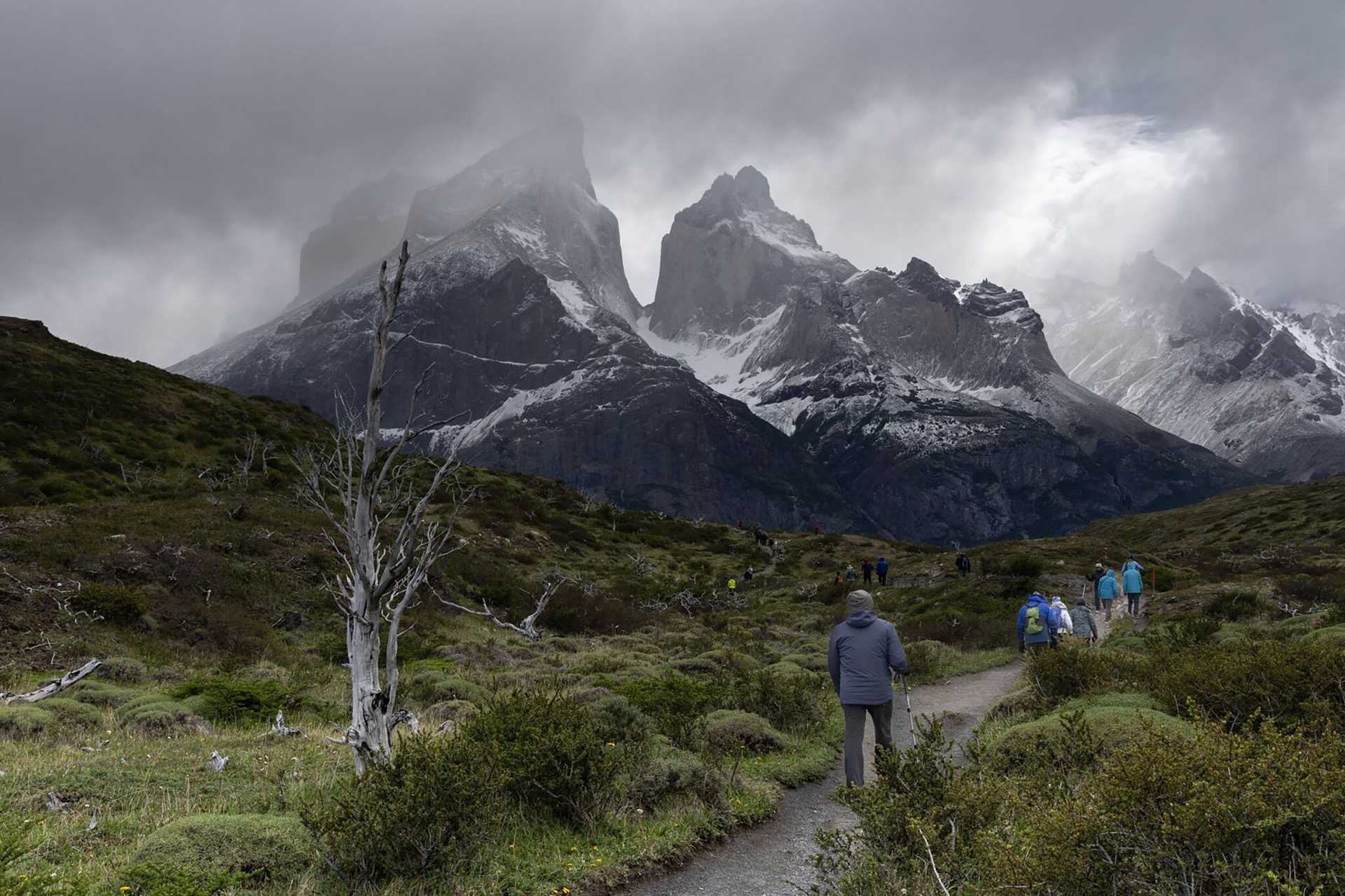 hikers in front of a large mountain in Torres del Paine National Park