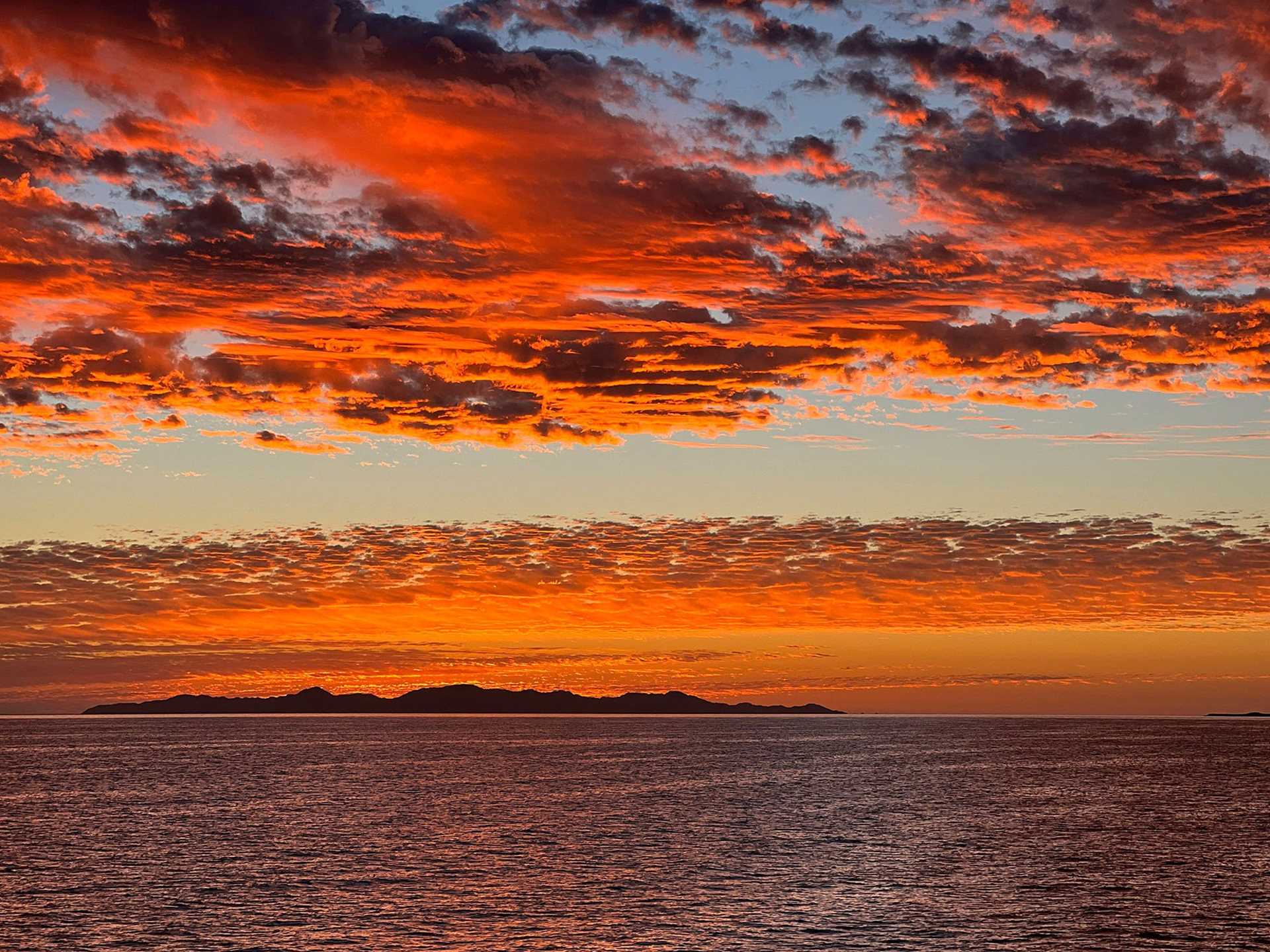 red and pink sunset over water