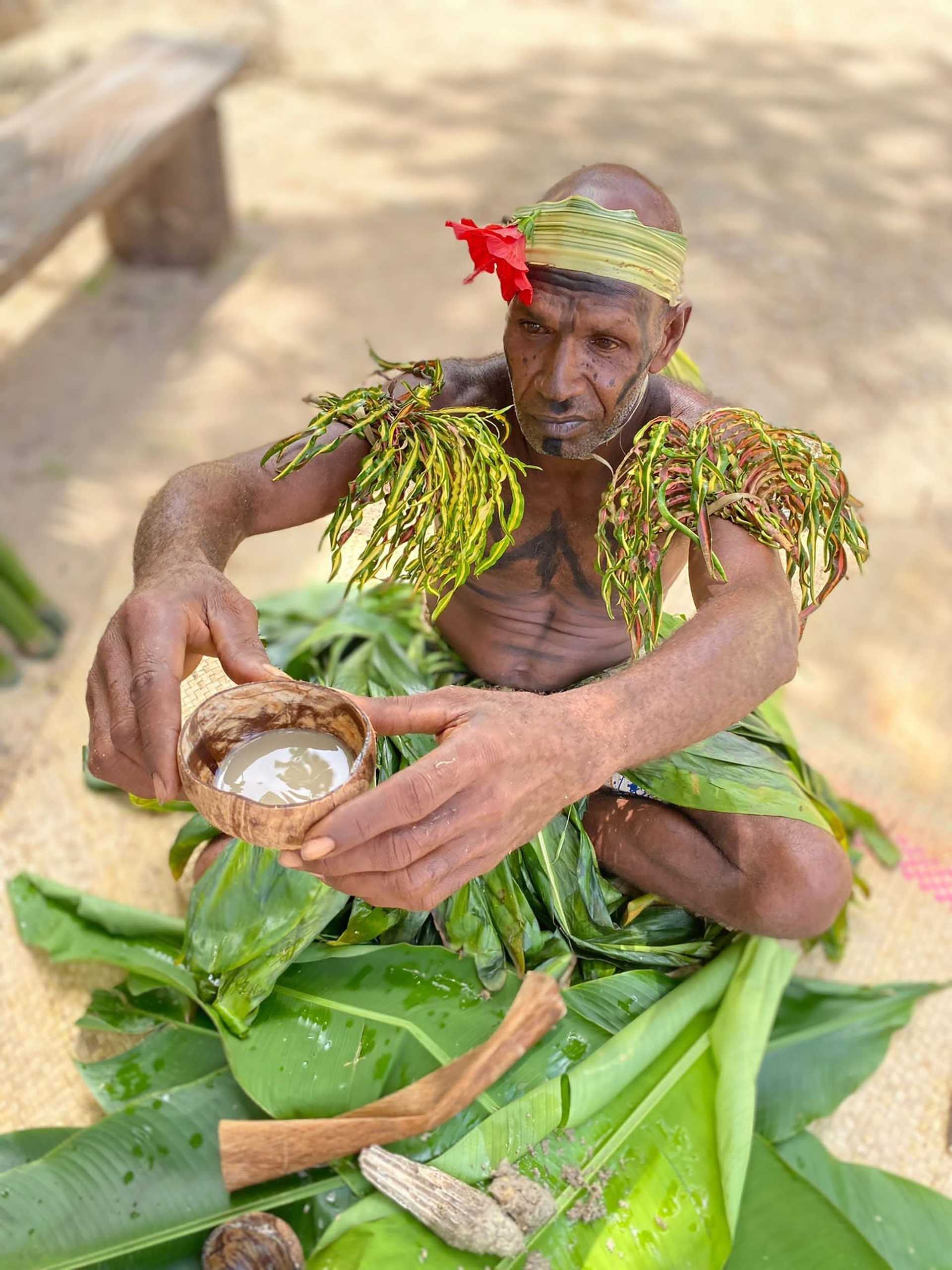 man from Vanuatu in traditional garb holding a cup